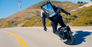 riding an electric unicycle down a sunny mountain road